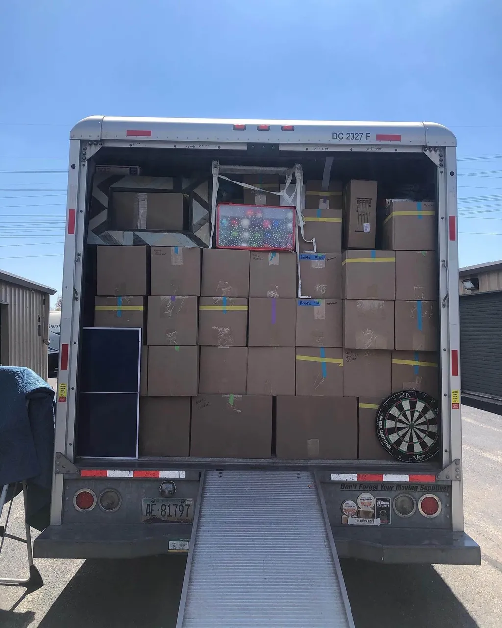 Moving truck packed floor to ceiling with neatly stacked, strapped cardboard boxes