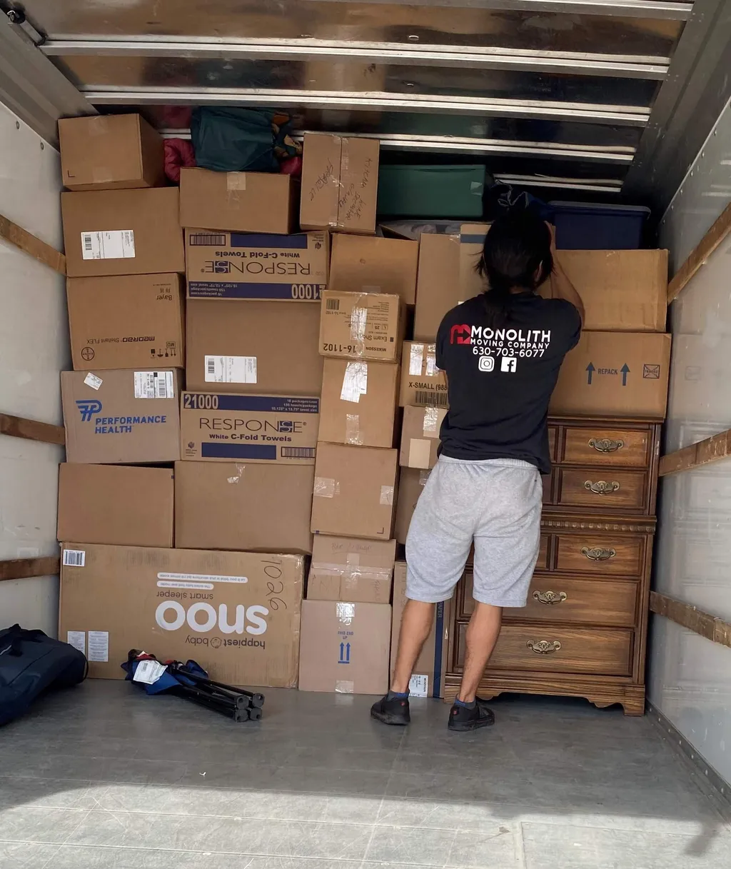 Monolith Moving Company team member organizing packed boxes inside a moving truck